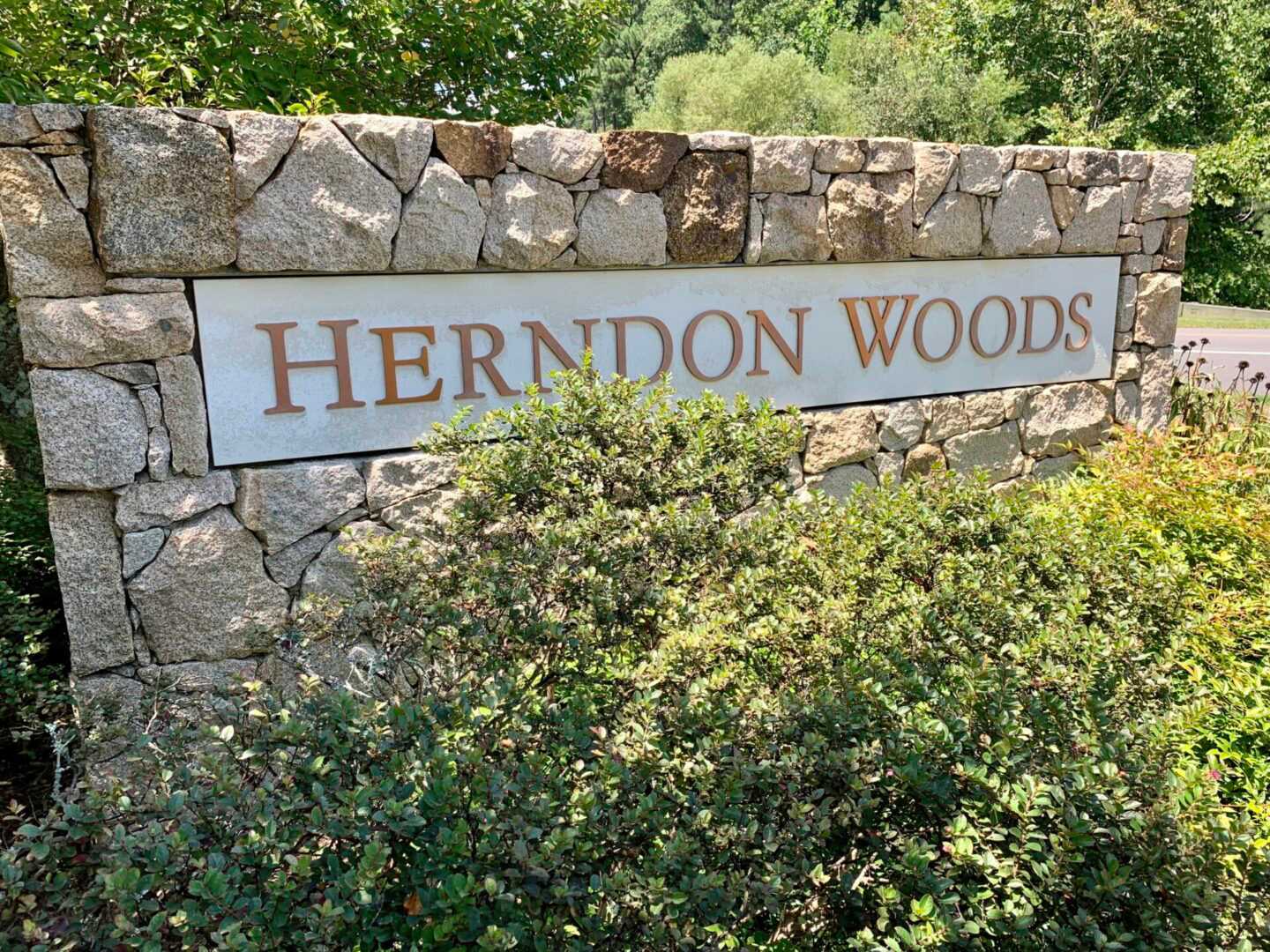 Herndon Woods Name on a wall behind bushes